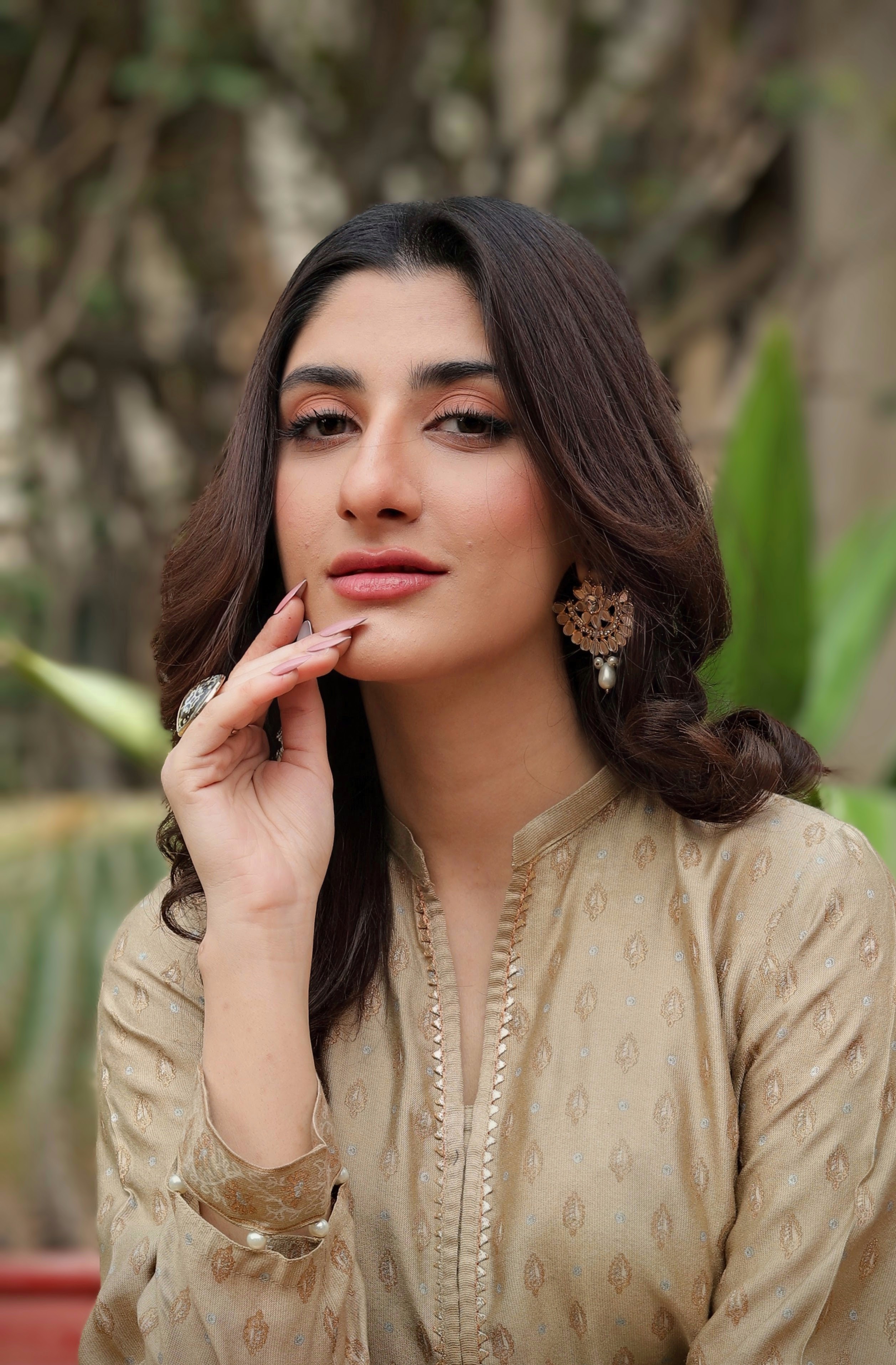 Close-up portrait of woman wearing beige traditional dress with jewelry